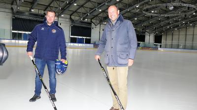 Der Chef der Bisons, Tobias Nuffer sowie Parkhotel-Sprecher Johannes Schweizer stehen mit Eishockeyschlägern in der Hand auf der Eisfläche der Pforzheimer St. Maur-Halle.
