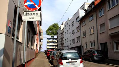 Autos parken in der Ebersteinstraße Pforzheim zwischen dreistöckigen Häusern. Davor steht ein Parkschild „Bewohner frei“.