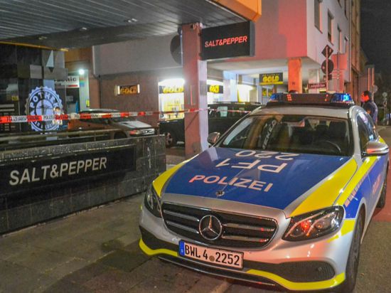 Ein Polizeifahrzeug steht neben einem Absperrband in Pforzheim.
