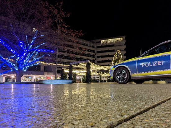 Die Weihnachtsbeleuchtung am Rathaus in Pforzheim können in der Nacht zum Sonntag immerhin die Polizisten genießen, die die Einhaltung der Ausgangssperre überwachen. Ein Polizeiauto steht vor dem gold und blau illuminierten Rathaus-