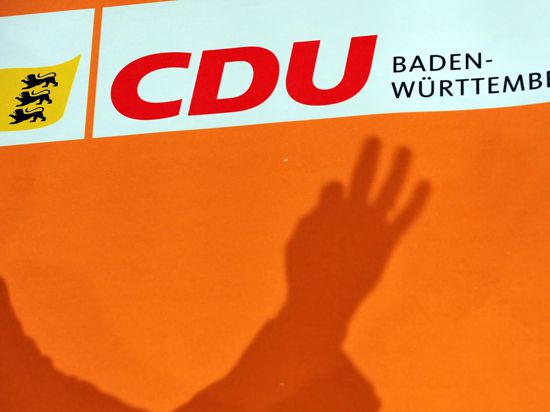 Der Schatten einer Hand über dem Parteilogo der CDU Baden-Württemberg