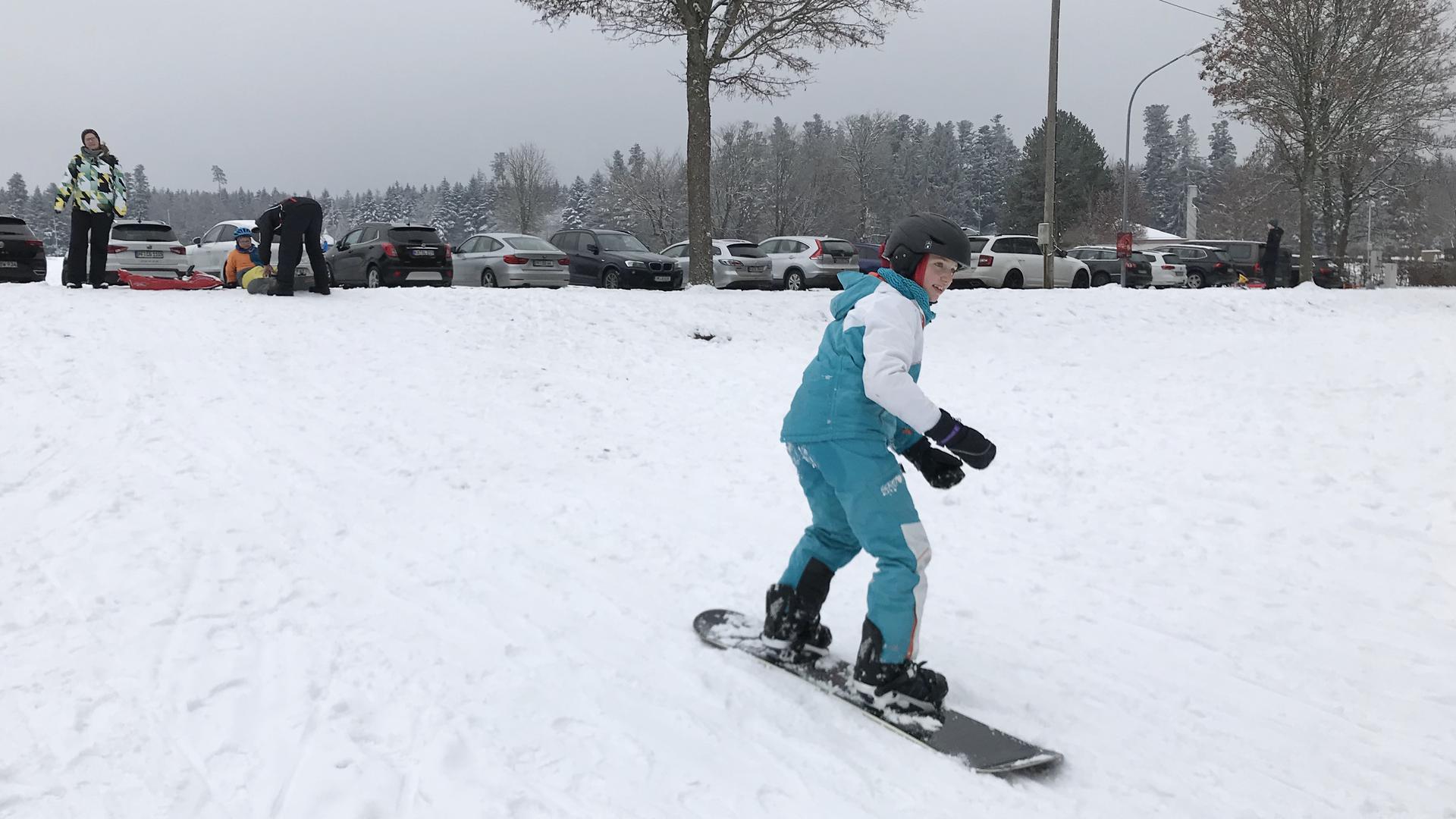 Ein Mädchen fährt Snowboard