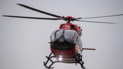 Ein Rettungshubschrauber fliegt über den Flugplatz eines Krankenhauses.