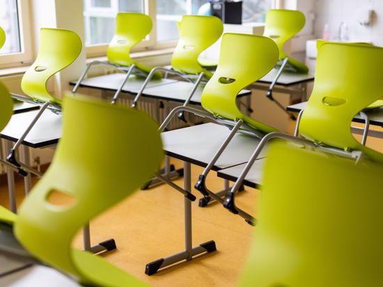 Stühle stehen auf Tischen in einem leeren Klassenzimmer einer Realschule. 