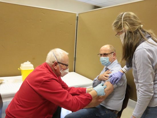 Beim Impfen: Wolfgang Balerin setzt die Spritze bei Andreas Seufer, unterstützt von Christiane Ratz.