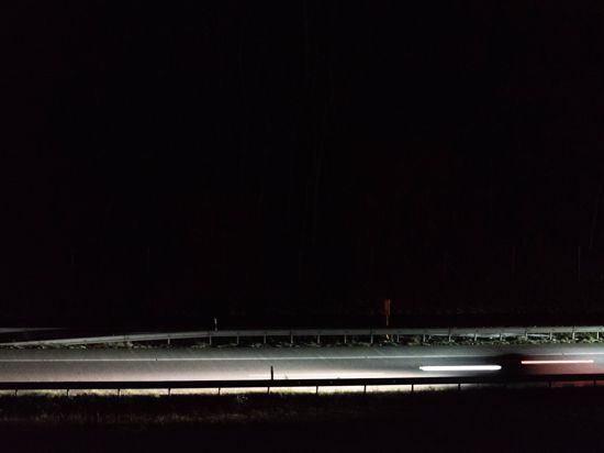 Ein Auto fährt nachts auf einer Straße (Symbolbild)