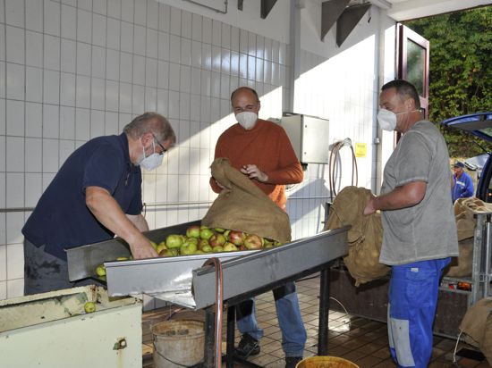Männer mit Äpfeln an Maschine