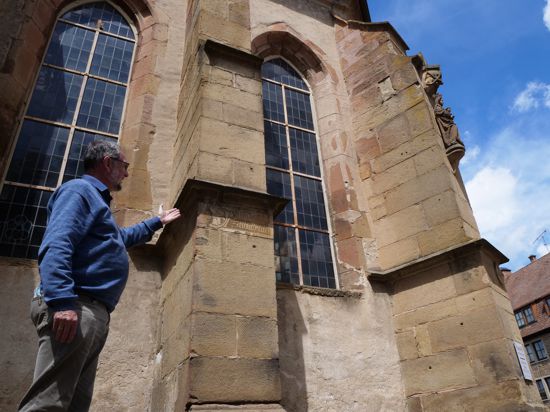 Pfarrer Hans Veit zeigt die Stellen an der Außenfassade des Chorraums, an denen der Zahn der Zeit genagt hat