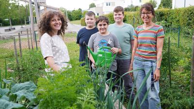Da kann der Nachwuchs etwas lernen: Wie man frisches Gemüse anbaut, zeigt Nicoleta Morariu (links) den Comeniusschülern, sehr zur Freude von Rektorin Angelika Schleider.