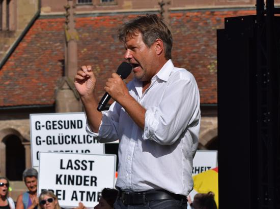 Robert Habeck in Maulbronn, im Hintergrund Demonstranten
