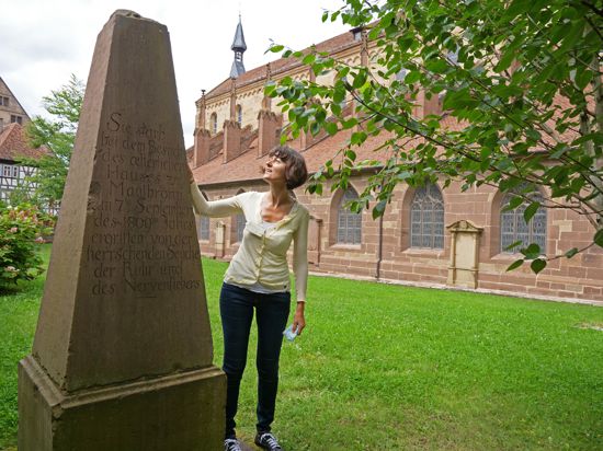 Eine Frau steht neben einem Obelisken