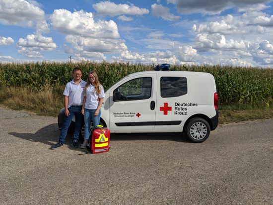 Tobias Wichmann und Luisa Wüst vom DRK-Ortsverein Neulingen stehen vor einem Auto des DRK-Ortsvereins Neulingen.