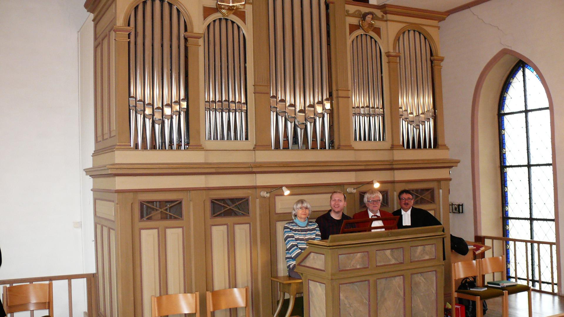 Zu viert auf der Bank vor der Orgel aus dem Jahre 1893 in der Nußbaumer Kirche Sankt Stephan sitzen von links Gisela Schuhmacher, seit 28 Jahren Organistin in Nußbaum und Sprantal, Sascha Dubronner, seit 13 Jahren Organist, der Orgel- und Glockensachverständige Martin Kares und Gemeindepfarrer Reinhard Ehmann.