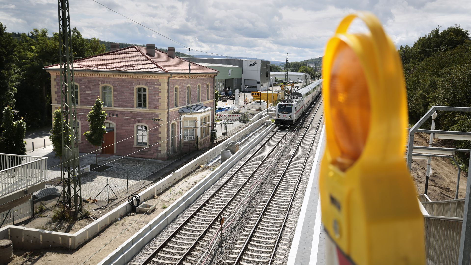 Der Bahnhof Niefern von schräg oben fotografiert. Ein IC hält Durchfahrt. Es sind Bauarbeiten am Bahnsteig zu sehen.