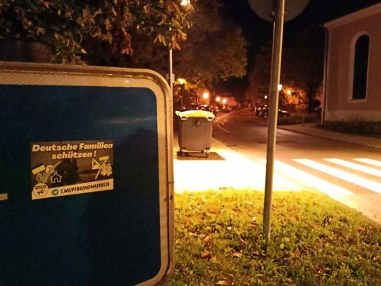 Auf einen Verkehrsschild ist ein Aufkleber mit der Aufschrift „Deutsche Familien schützen“ angebracht