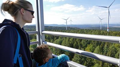Eine Frau und ein Kind blicken auf die Anlagen im Windpark Straubenhardt.