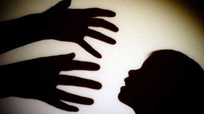 Symbolbild zeigt Schattenbild von Händen, die nach einem Kind greifen.