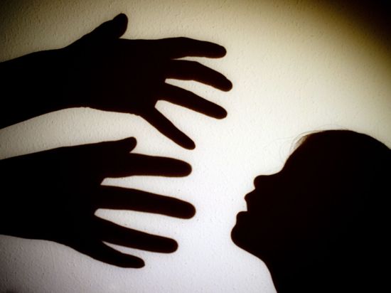 Symbolbild zeigt Schattenbild von Händen, die nach einem Kind greifen.
