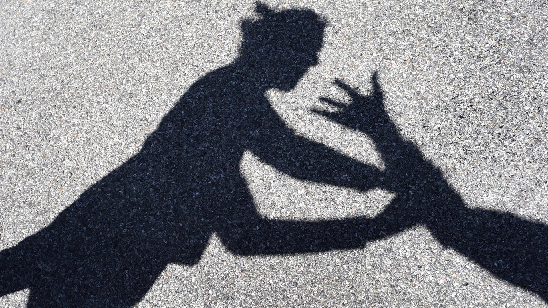 Schatten auf dem Boden: Mann erhebt Hand gegen Frau