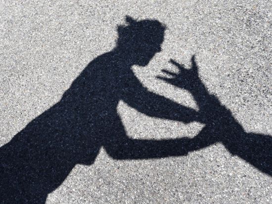 Schatten auf dem Boden: Mann erhebt Hand gegen Frau