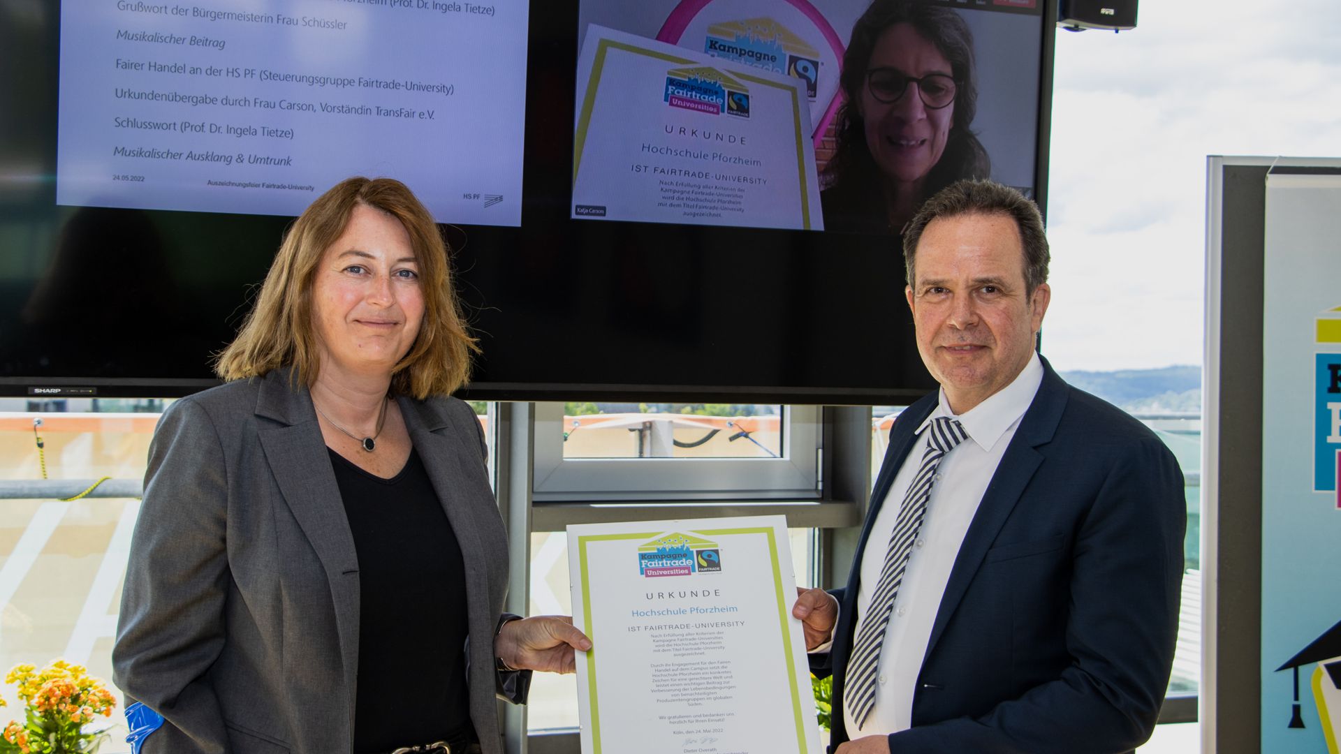 Urkunde als Bestätigung: Prorektorin Ingela Tietze und Rektor Ulrich Jautz freuen sich über die Auszeichnung als Fairtrade-University, die ihnen Katja Carson vom Verein Fairtrade Deutschland per Video-Schalte überreicht.