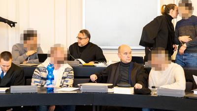 Beratungsbedarf:Die vier Angeklagten besprechen sich mit ihren Rechtsanwälten Manuel Frank, Kristian Frank, Axel Küster und Vanessa Höch (von links, in schwarzen Roben).