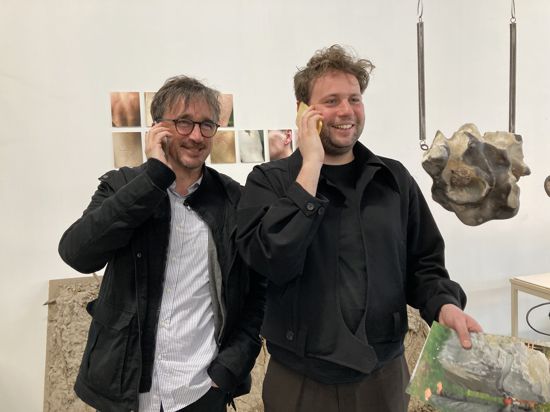 Christian Saalfrank und Jules van den Langenberg (von links) haben Spaß mit Stein-Handys von Wiktoria Wojciechowska , in deren Atelier in Paris