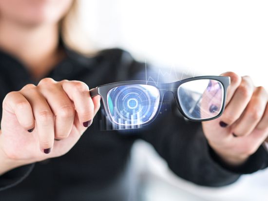 Person holding nanotech smart glasses. Eyewear with interactive augmented reality (AR) interface and screen with visual digital sensor. Futuristic cyber and nano technology. Modern nanotechnology.