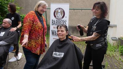 Annelies Gensler (mit buntem Dress) vom Team der Suppenküche weiß, wie wichtig ein gepflegter Haarschnitt auch für ihre Gäste ist, die sich den Friseurbesuch nicht leisten können. Darum kümmern sich ehrenamtliche Barber Angels, die zu Besuch in Pforzheim sind. 