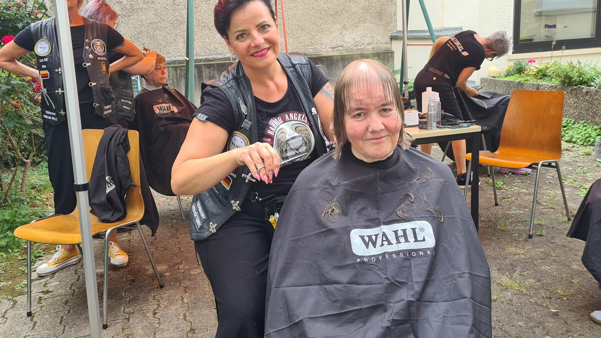 Barber Angel Bärbel Schöner schneidet in ihrer Freizeit Heike Hattig (auf dem Stuhl vorne sitzend) und vielen weiteren Suppenküche-Gästen am Sonntagnachmittag die Haare. 