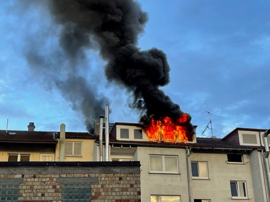Brennender Dachstuhl eines Mehrfamilienhauses mit hoher Rauchsäule.