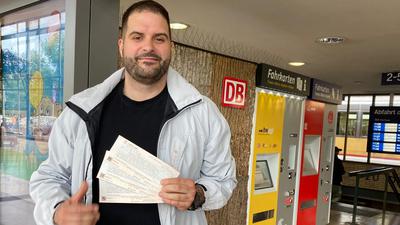 Junger Mann mit drei 9-Euro-Tickets am Pforzheimer Hauptbahnhof