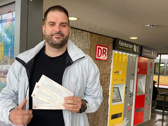 Junger Mann mit drei 9-Euro-Tickets am Pforzheimer Hauptbahnhof