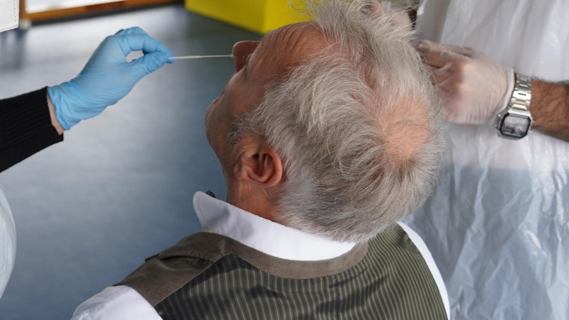 Mann bekommt im Testzentrum von Witzenmann in Pforzheim Teststäbchen in die Nase geführt