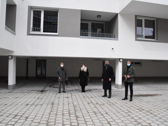 Vier Personen stehen vor einem Gebäude.