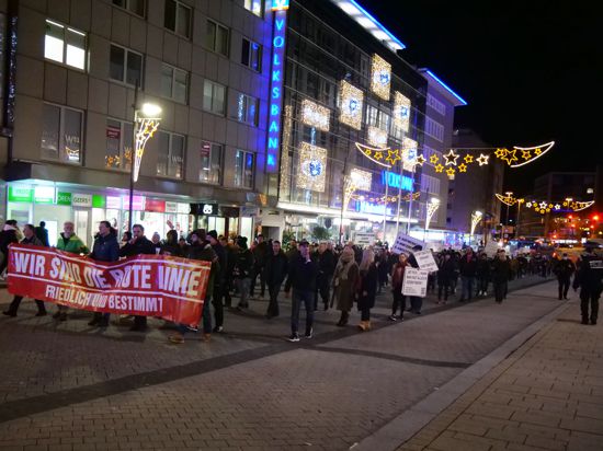 Ein Demonstrationszug zieht durch die Innenstadt. Auf dem vordersten Banner steht „Wir sind die Rote Linie. Friedlich und bestimmt“.