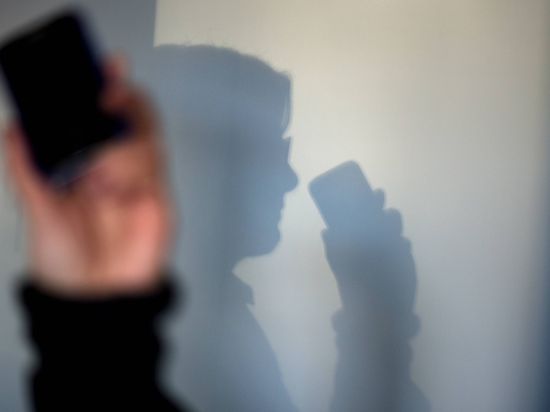 ARCHIV - ILLUSTRATION - Eine Frau telefoniert am 16.12.2013 in Dresden (Sachsen) mit ihrem Mobiltelefon an der Wand zeichnet sich ihr Schatten ab. (zu dpa "Polen prüft Auslieferung von Enkeltrick-Betrüger" am 22.03.2017) Foto: Arno Burgi/dpa-Zentralbild/dpa +++(c) dpa - Bildfunk+++ | Verwendung weltweit
