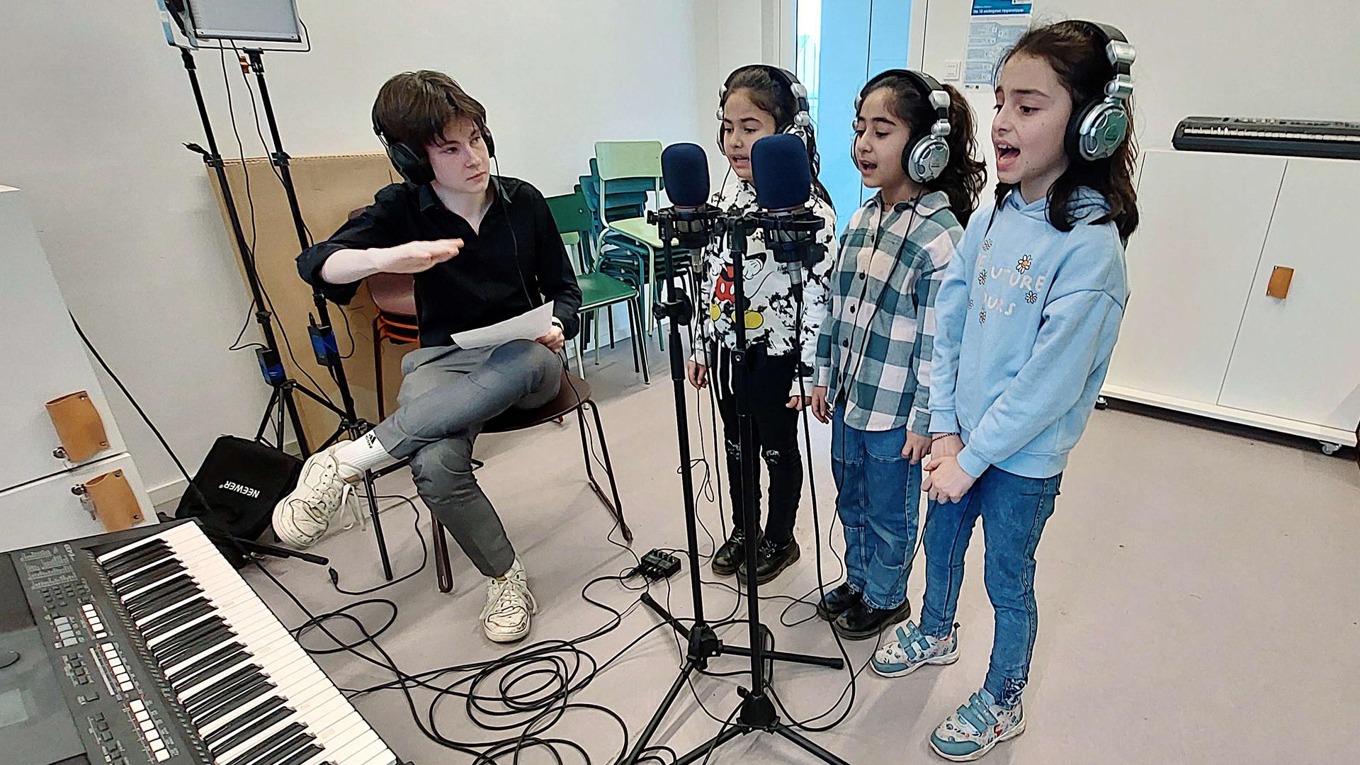Ein Lied für den Frieden produzieren Kinder und Jugendliche im Haus der Jugend. Evlin, Elaf und Savinja nehmen im Studio ihre Gesangsparts auf, Aufnahmeassistent Leon Meyer (li.) dirigiert. 