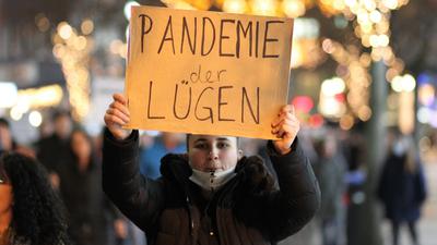 Wer lügt? Eine Demonstrantin hält am Montagabend in der Pforzheimer Bahnhofstraße ein handgeschriebenes Plakat mit der Aufschrift „Pandemie der Lügen“ hoch. 