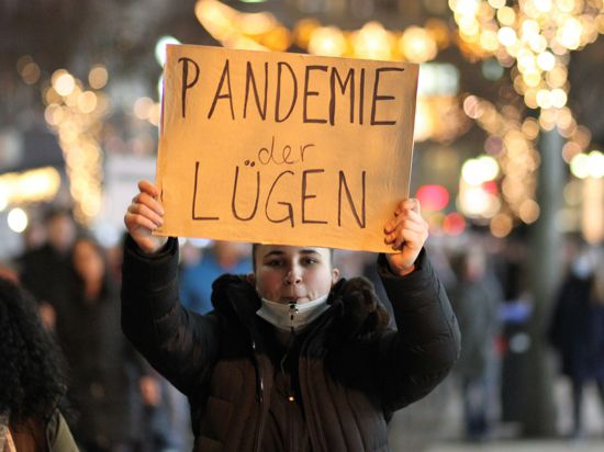 Wer lügt? Eine Demonstrantin hält am Montagabend in der Pforzheimer Bahnhofstraße ein handgeschriebenes Plakat mit der Aufschrift „Pandemie der Lügen“ hoch. 
