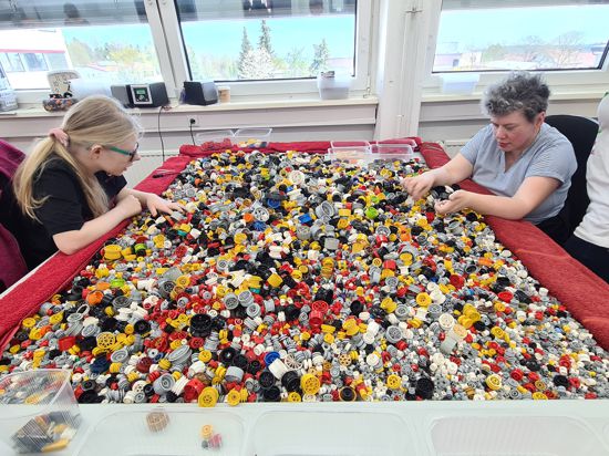 Katharina (links) und Silja sortieren Lego-Räder.