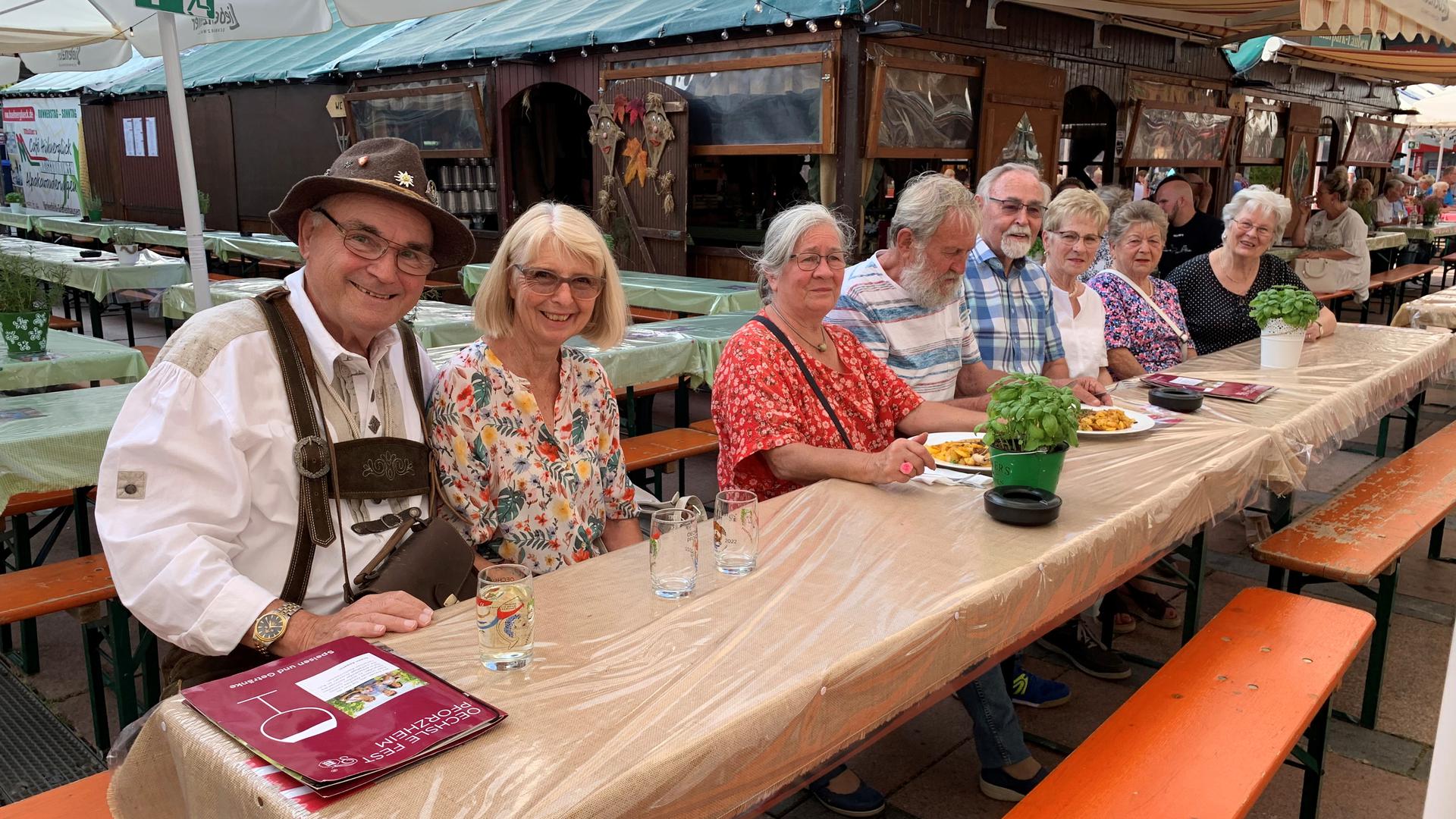 Besucher sitzen an einem Tisch auf dem Oechsle Fest Pforzheim.