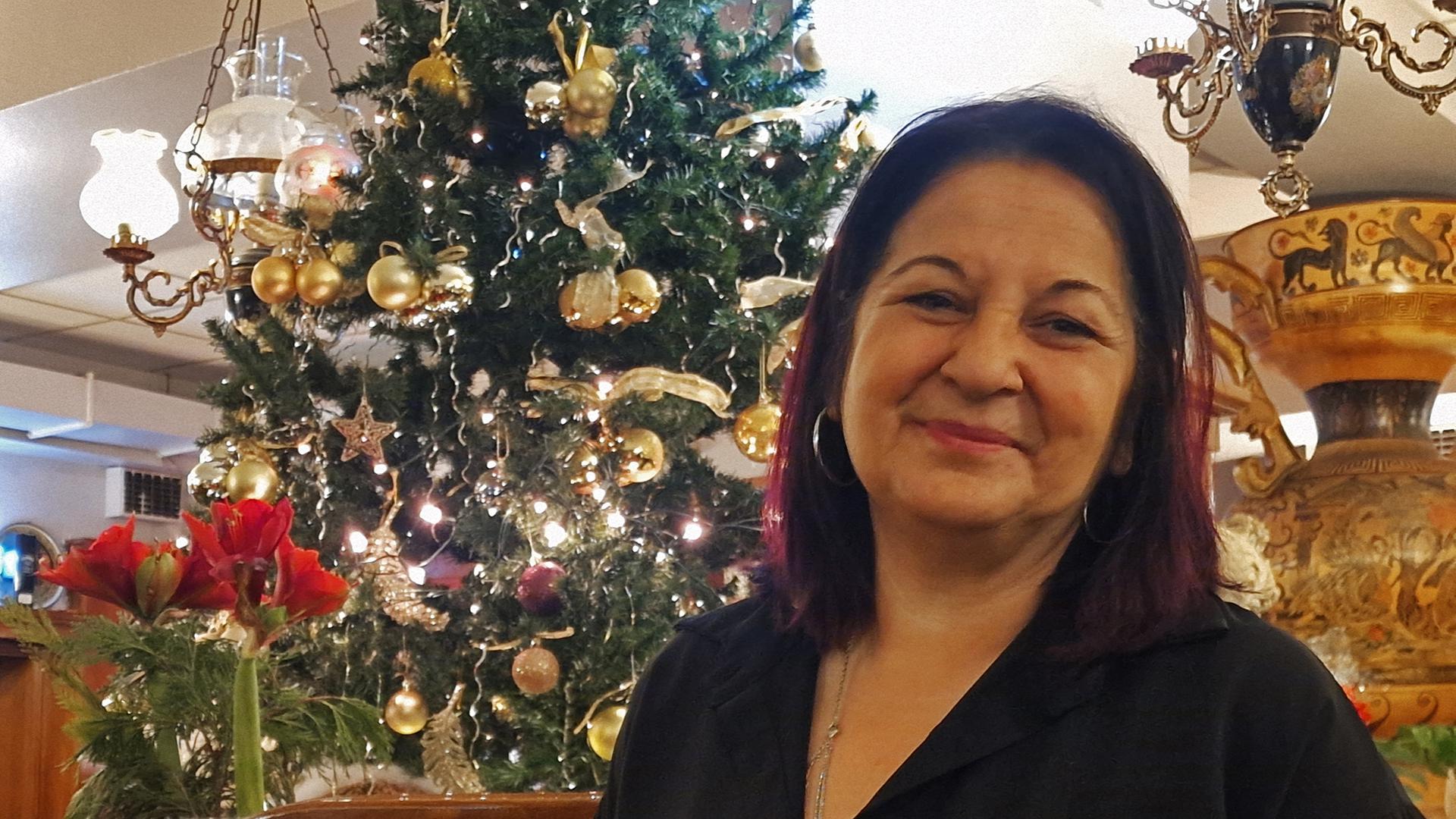 Frau vor geschmücktem Weihnachtsbaum in Restaurant