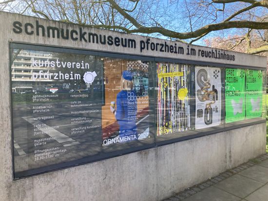 Ein Plakat, das auf die Ornamenta hinweist, hängt im Glaskasten vor dem Schmuckmuseum im Reuchlinhaus in Pforzheim.