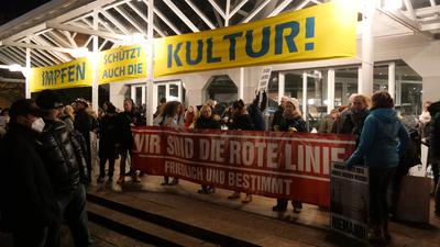 Die Teilnehmer der Corona-Demonstration in Pforzheim mit ihrem Banner unter dem Schild „Impfen schützt auch die Kultur“
