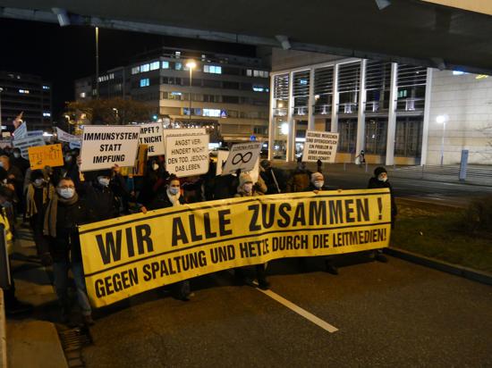 Ein gelbes Banner mit den Worten „Wir alle zusammen! Gegen Spaltung und Hetze durch die Leitmedien“ bei der Corona-Demonstration in Pforzheim.