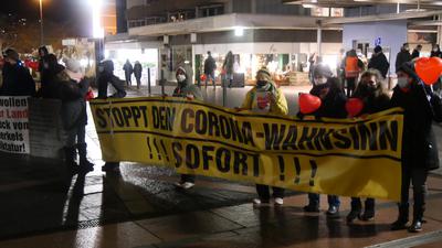 Ein Gelbes Banner mit der Aufschrift „Stoppt den Corona-Wahnsinn !!! Sofort !!!“ bei der Corona-Demonstration in Pforzheim.