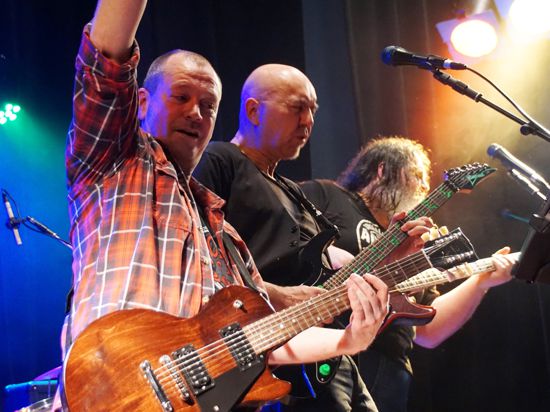 Drei der vier Musiker der Rock-Band „Cezanne“ stehen auf einer Bühne 