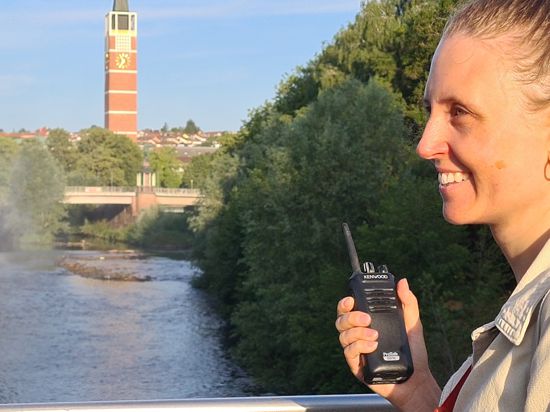 Veronika Sedlmair in Funkkontakt zu ihrem Partner Brynjar Sigurðarson, der am Flussufer den Wassernebel mit den Männern der technischen Dienste steuert