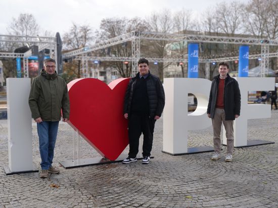 Drei Männer stehen vor einem Selfie Point mit der Botschaft I love PF